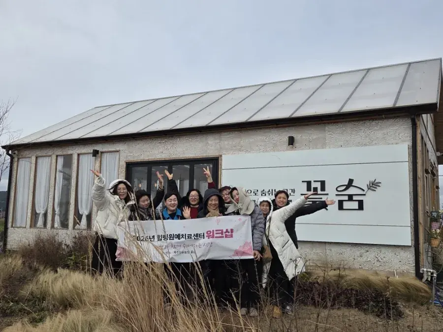 농장 건물 앞에서 현수막을 든 단체
